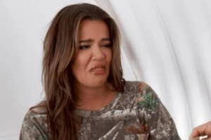 Khloe Kardashian scrunches her face and holds out her tongue as if disgusted