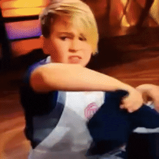 A child attempting to whip something on the stove very quickly