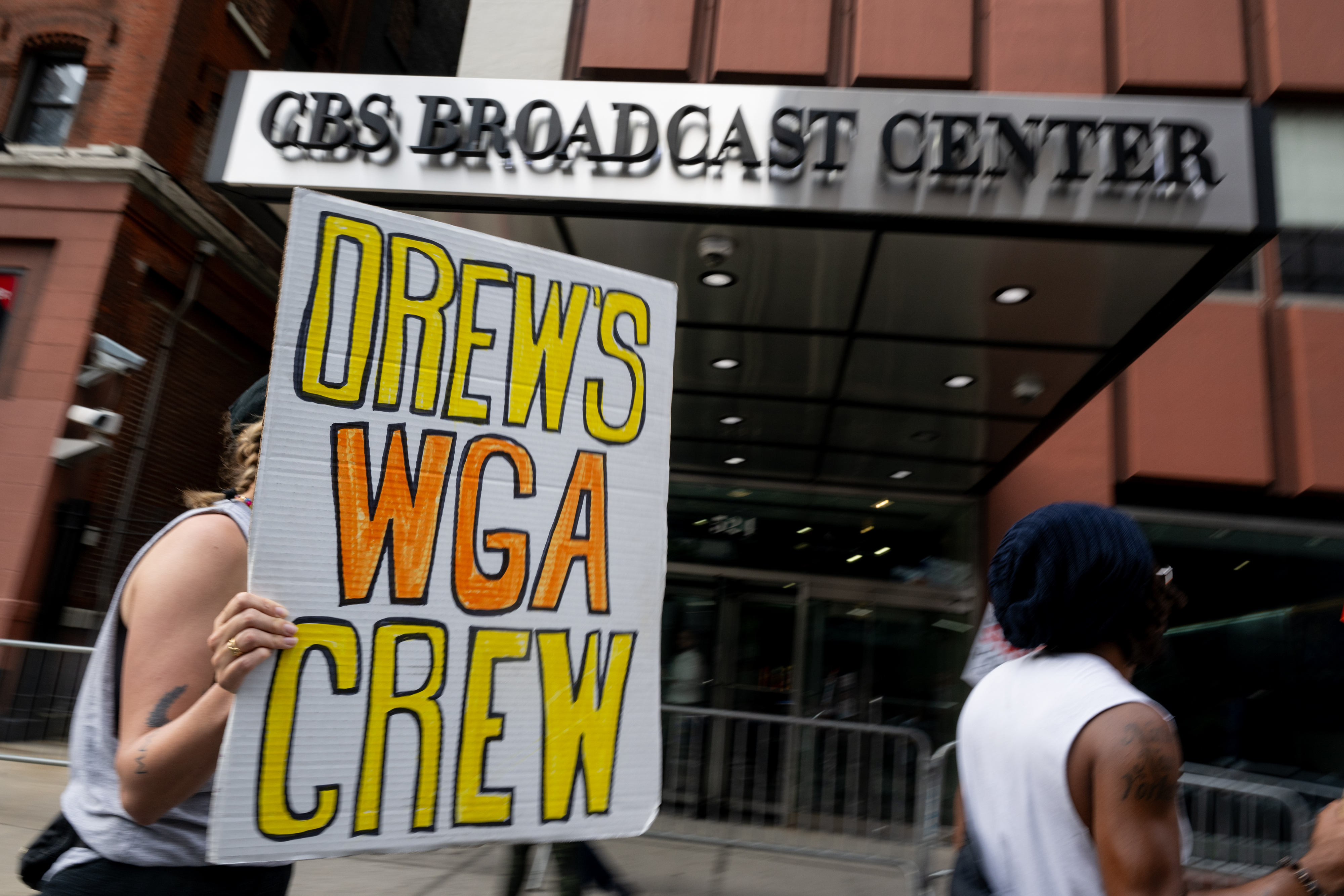 A person holding a sign that says, &quot;Drew&#x27;s WGA Crew&quot; outside the CBS Broadcast Center