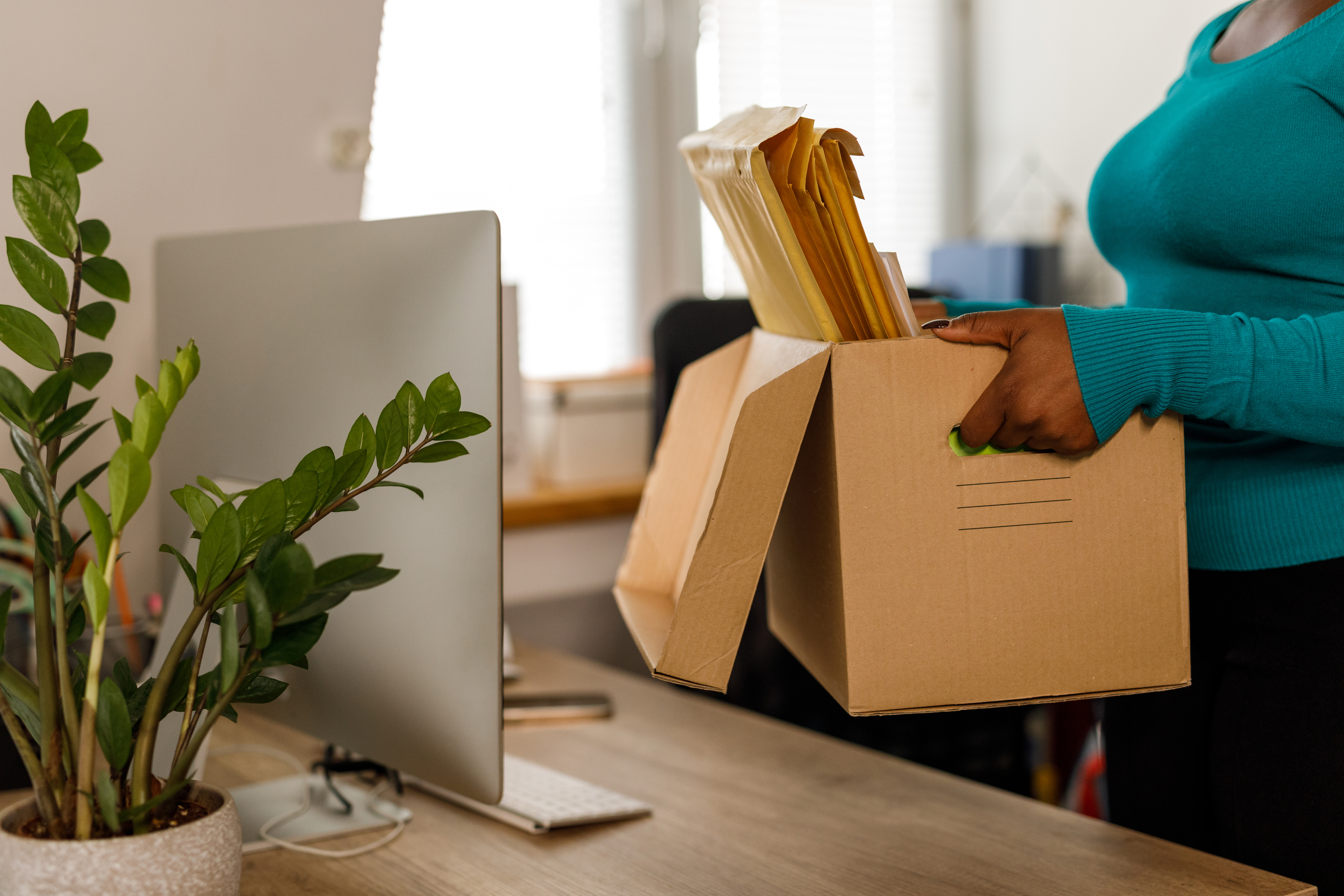 woman packing up her desk after a layoff