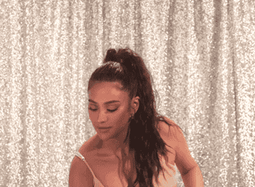 Shay Mitchell looking at a pregnancy test in shock