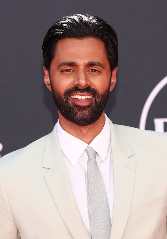 A closeup of Hasan Minhaj wearing a suit and tie