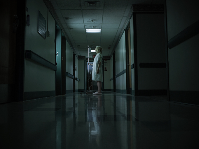 woman standing in a dark hospital hall