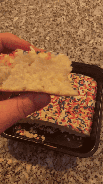 squeezing piece of cake to show how soft it is