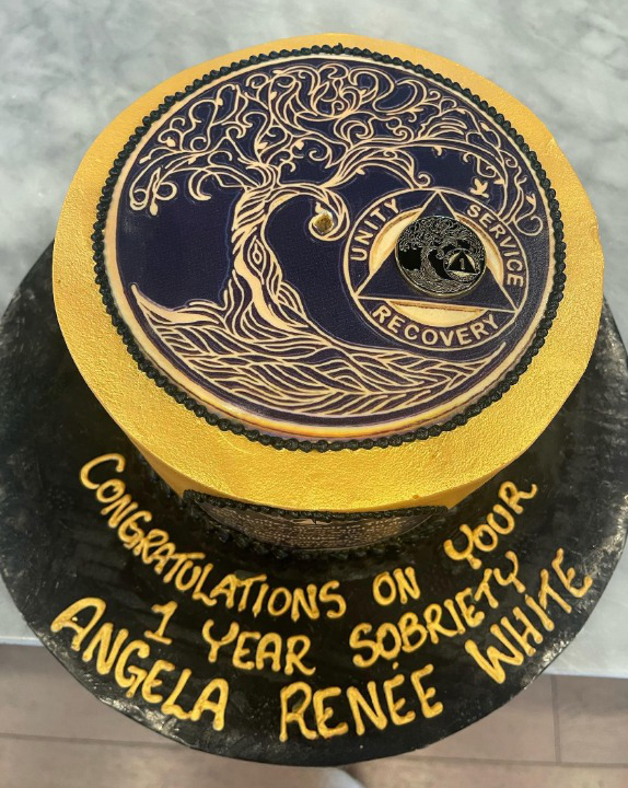 Close-up of cake with message: &quot;Congratulations on your 1 year sobriety Angela Renée White&quot;