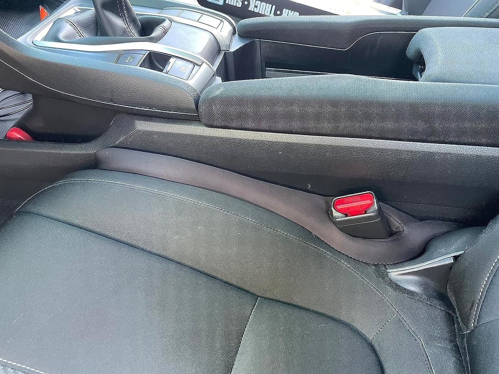 Reviewer&#x27;s photo of the seat gap filler in use
