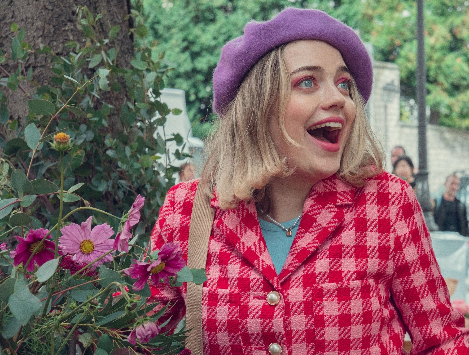 closeup of her outside wearing a beret and looking excited