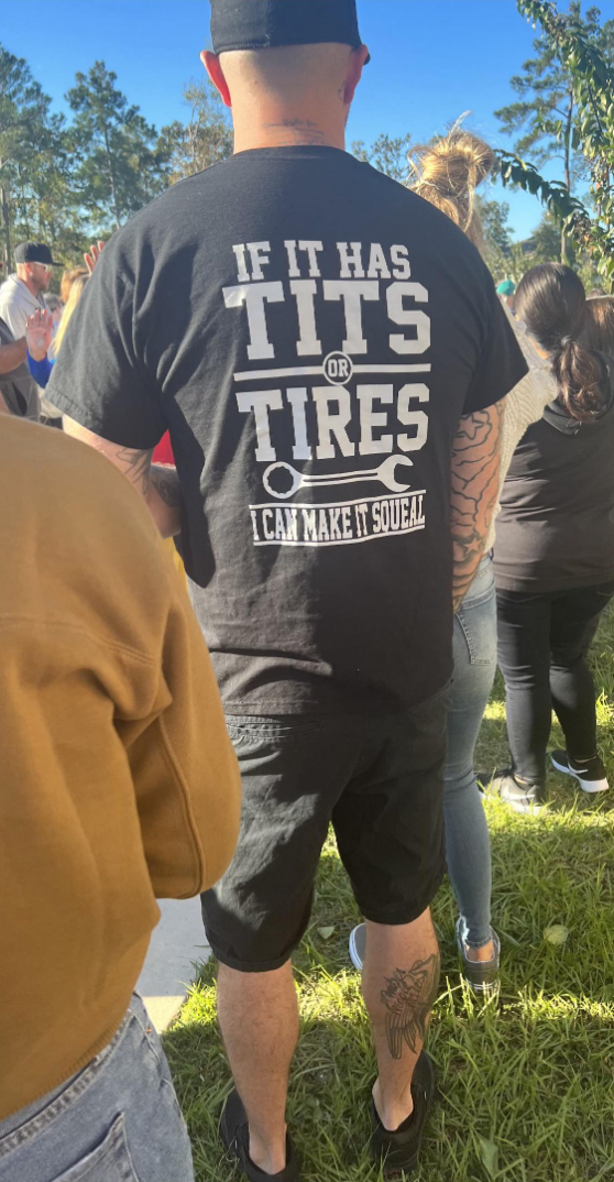 A man wearing a shirt that says &quot;if it has tits or tires, I can make it squeal&quot;