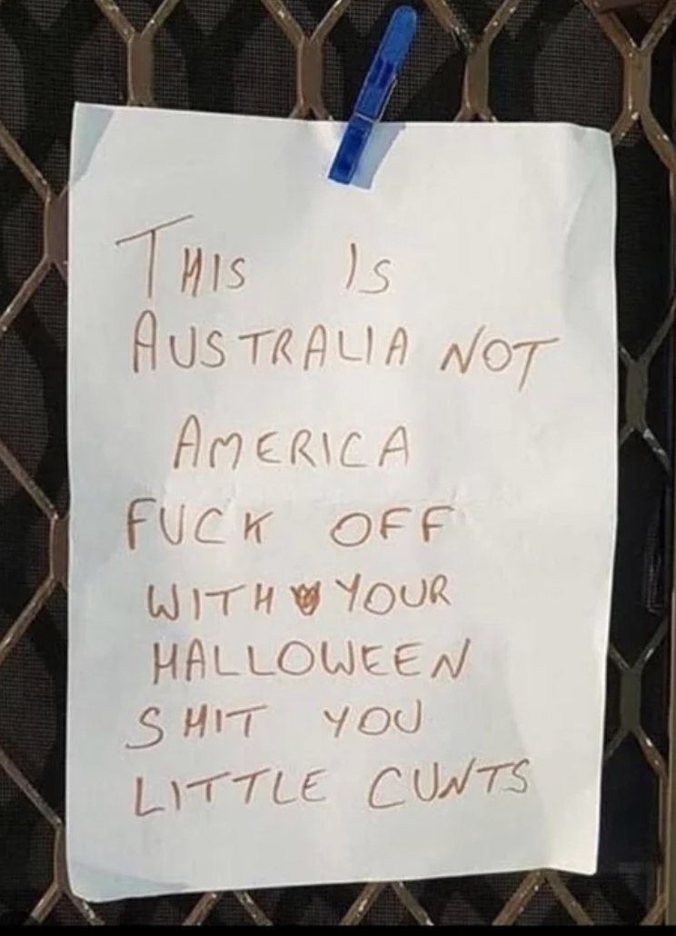 A sign reads "This is Australia not America, fuck off with your Halloween shit you little cunts"