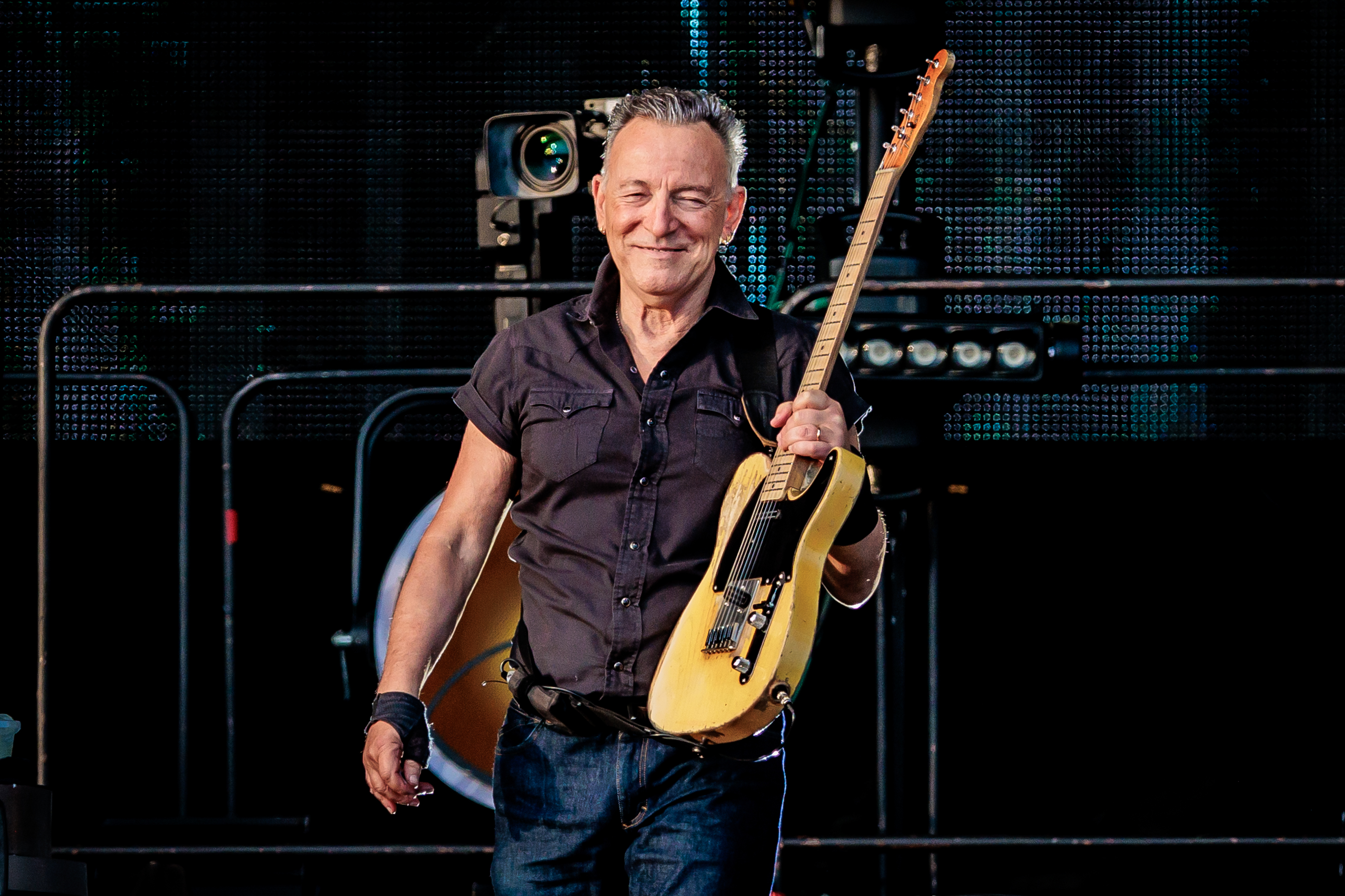 Bruce Springsteen holds his guitar as he stands on stage