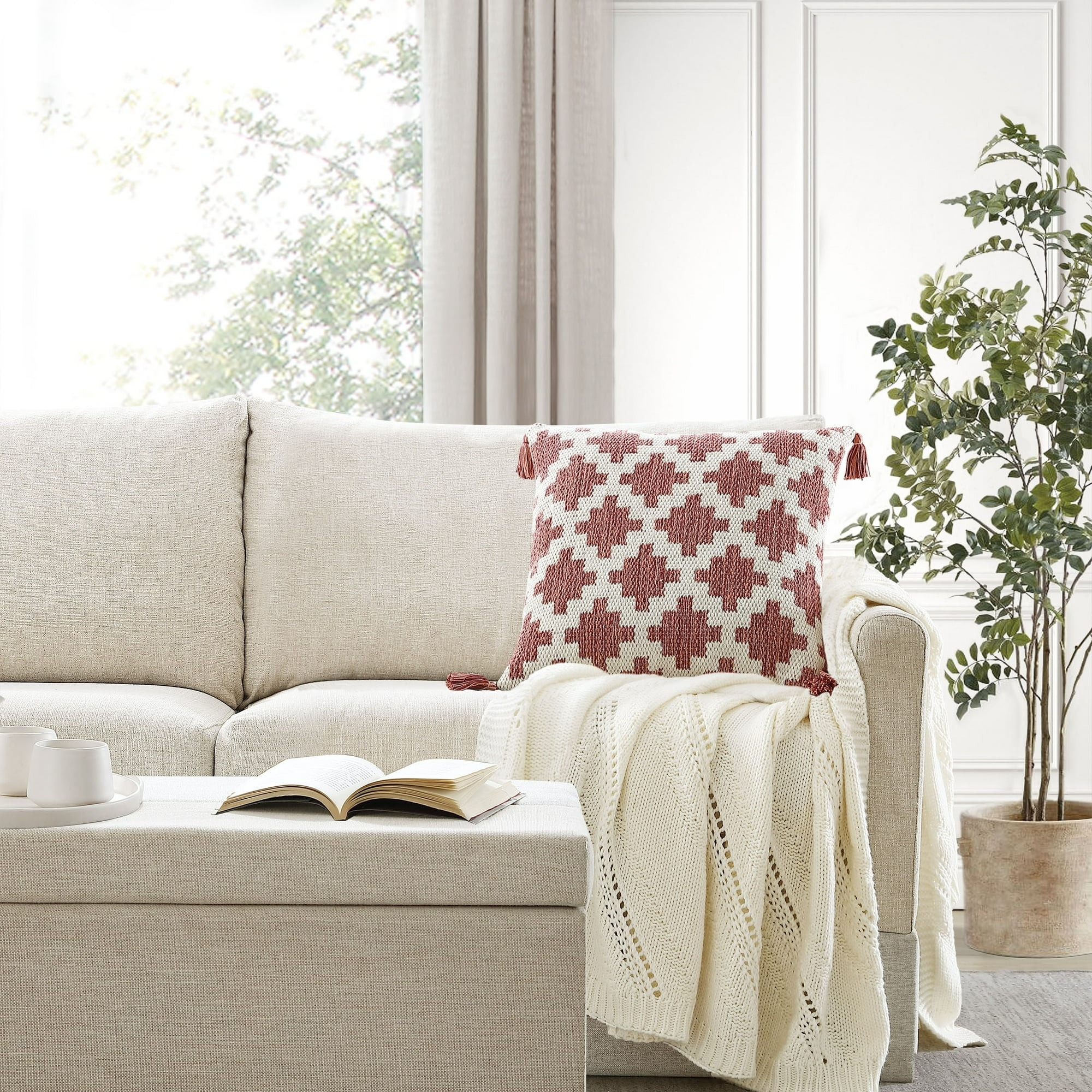 The red pillow with a geometric pattern resting on a couch