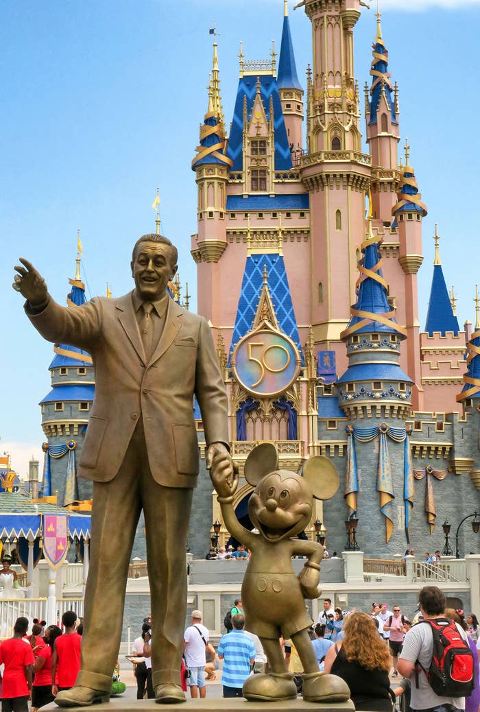 A statue of Walt Disney holding hands with Mickey Mouse