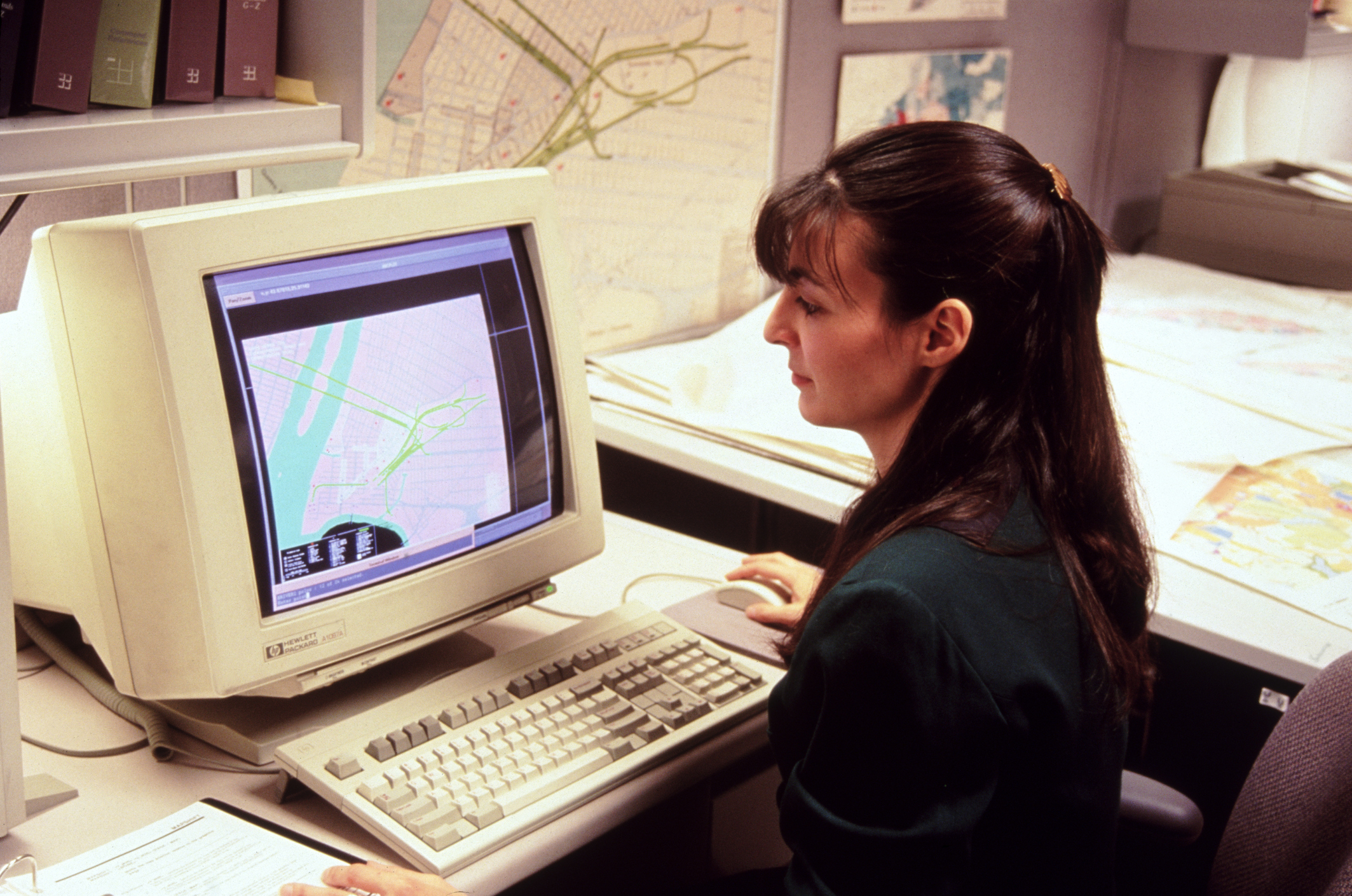 A woman is doing work on a retro computer