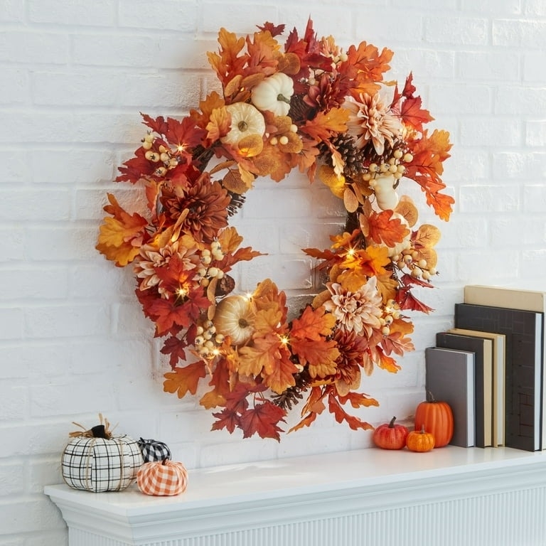 the wreath with lights and fall leaves over a mantle