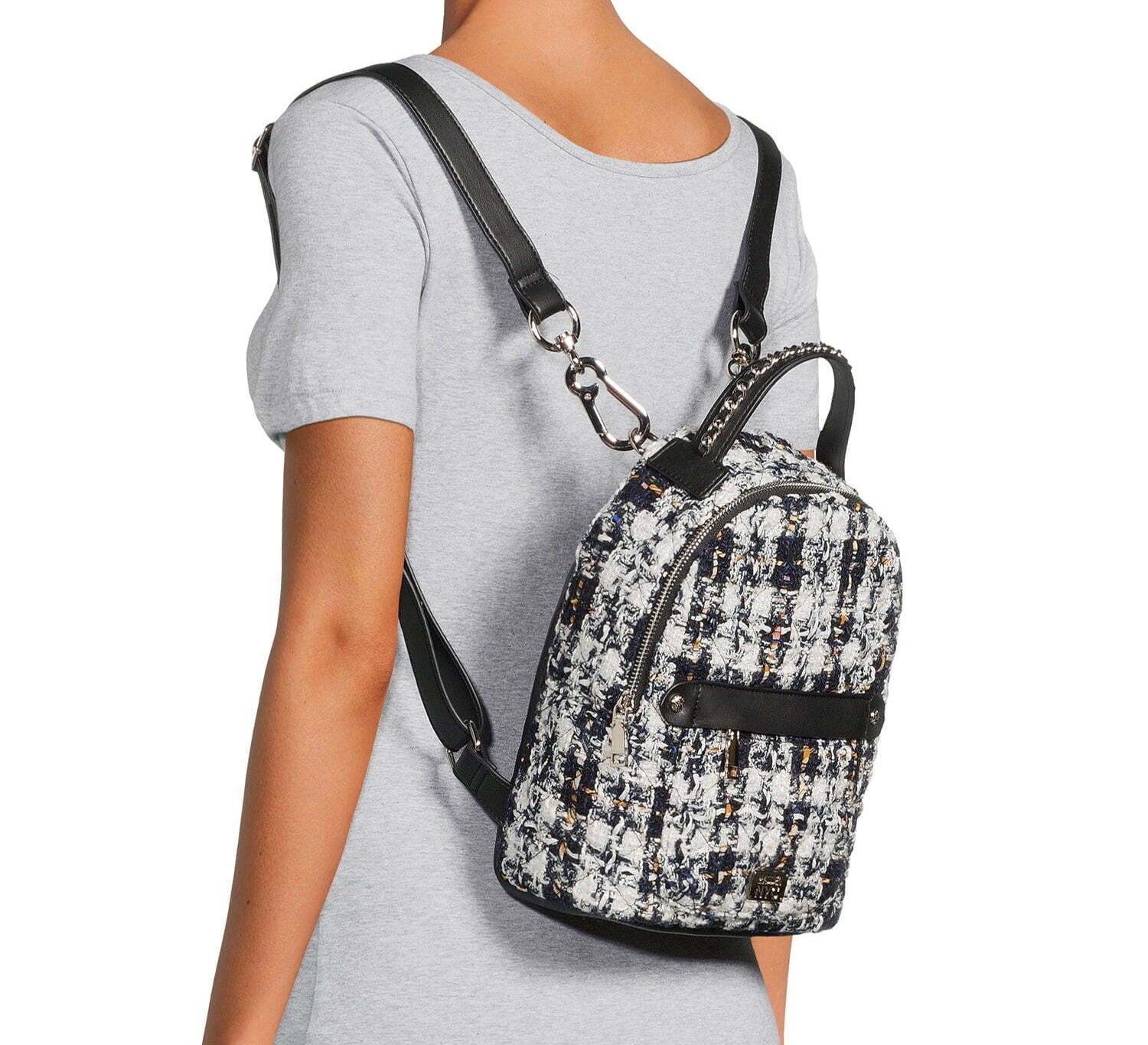 A model wearing the backpack in black and white tweed material