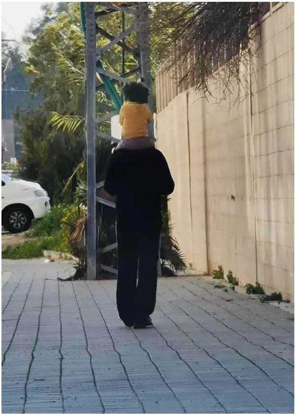 A man with their child on their shoulders