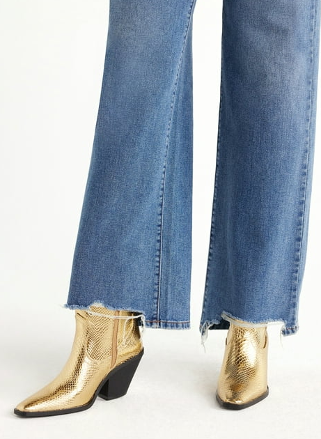 model wearing gold western-style booties with wide leg jeans