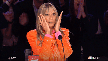Heidi Klum putting her hands to her face and exhaling deeply