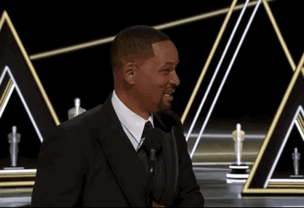 Will Smith waves in a tuxedo after receiving his Oscar.