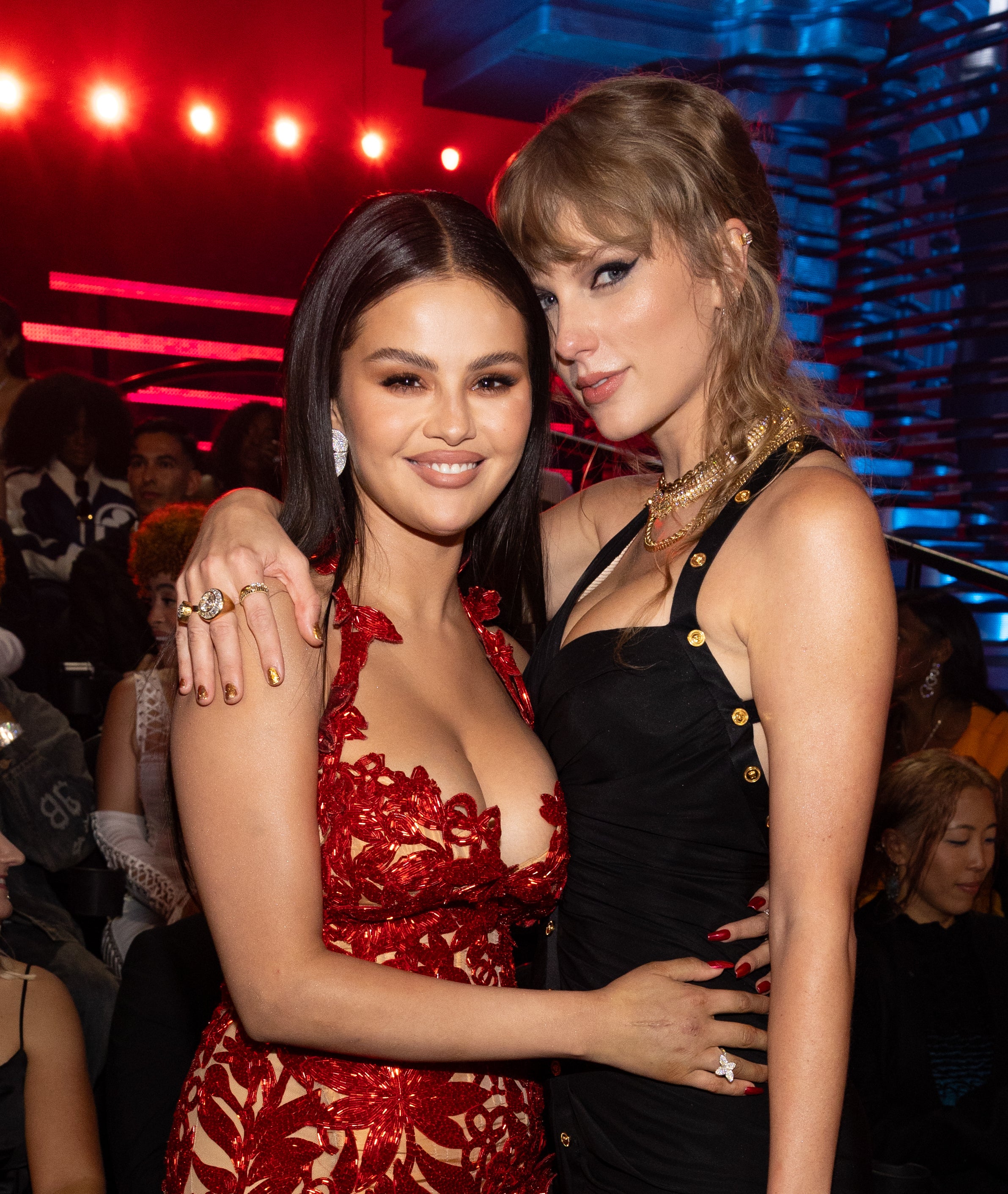 Selena and Taylor with their arms around each other as they smile for a photo at an awards show
