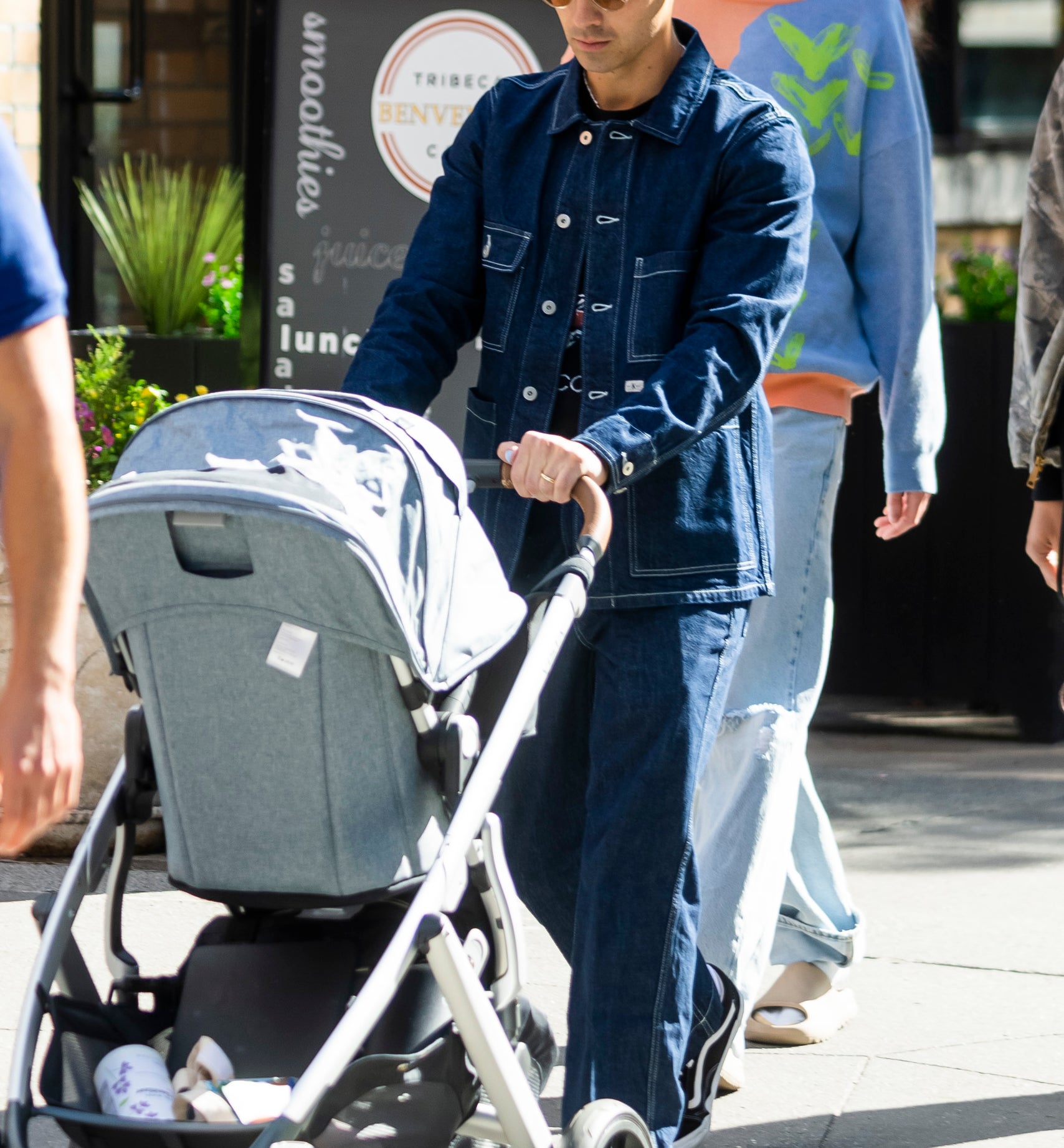 Joe Jonas pushing a baby stroller as Sophie Turner walks behind him