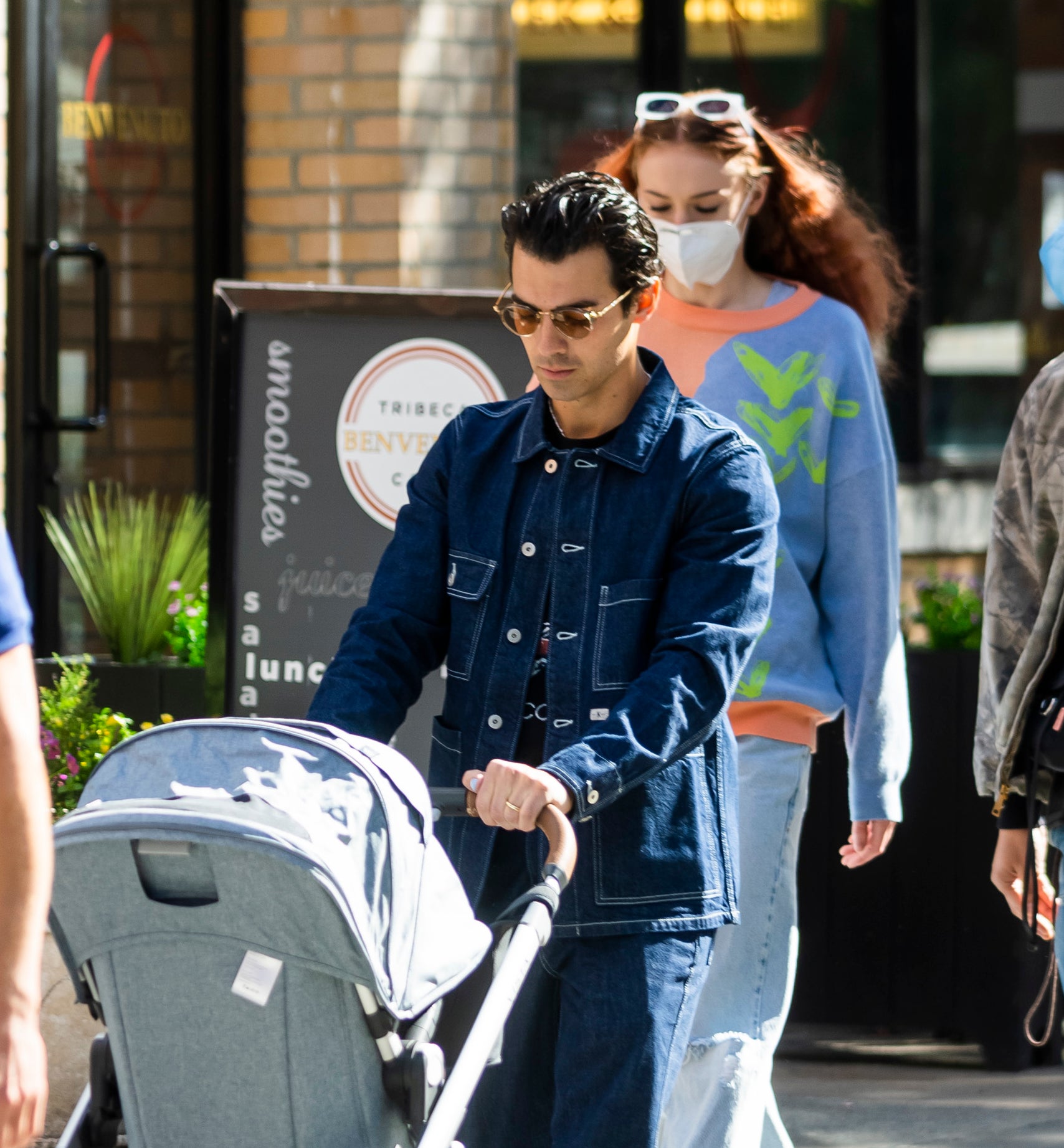 Joe Jonas pushing a baby stroller as Sophie Turner walks behind him