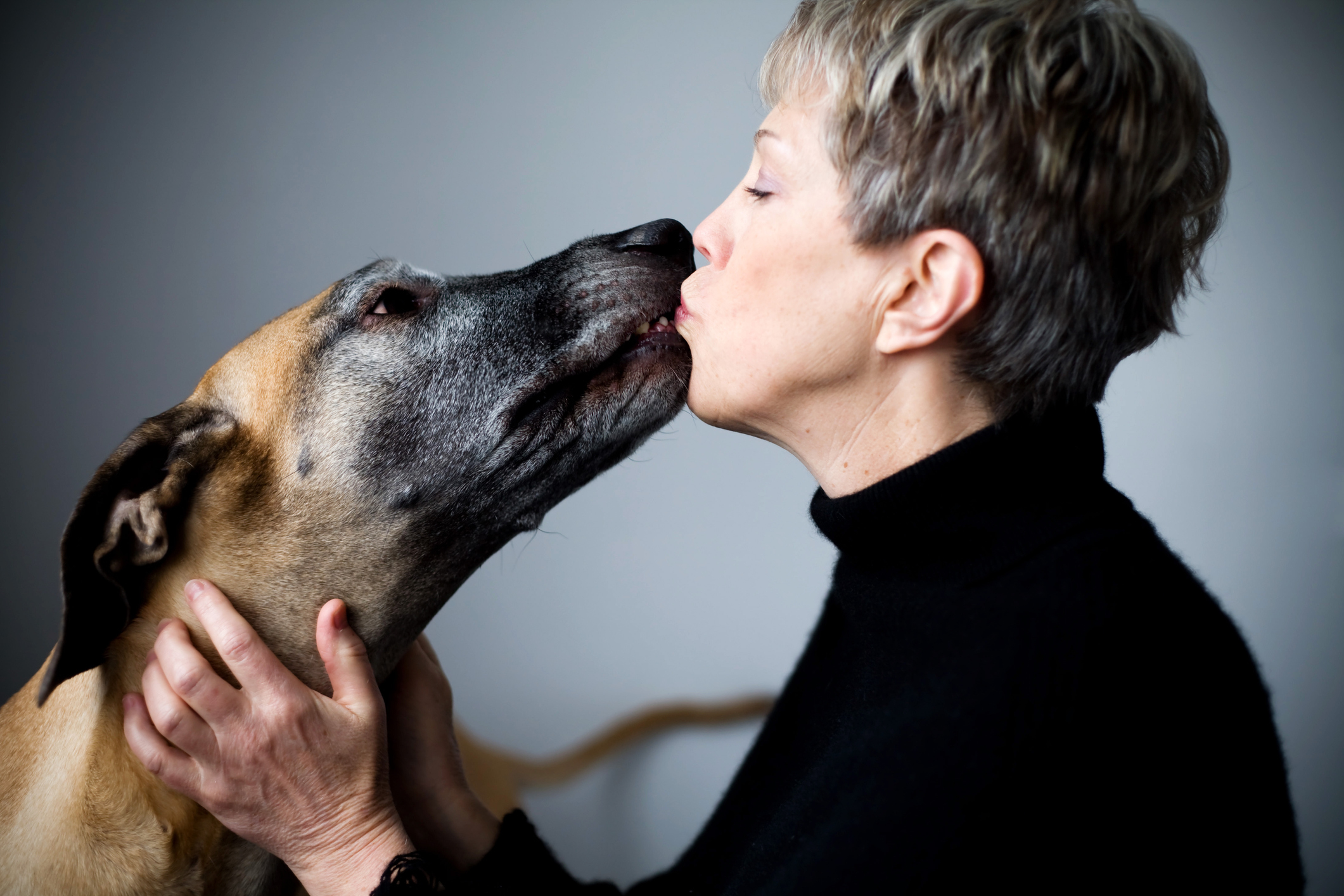 A woman kissing her dog