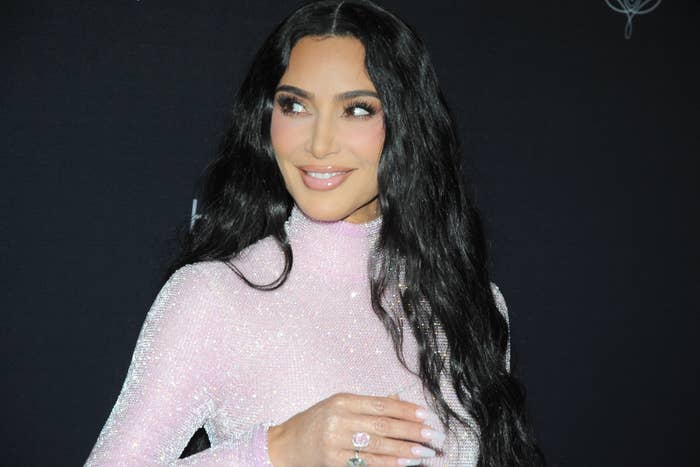 A closeup of Kim Kardashian in a long-sleeved high-necked sequin outfit