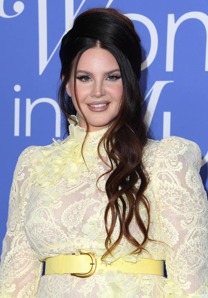 A closeup of Lana on the red carpet in a belted lace dress