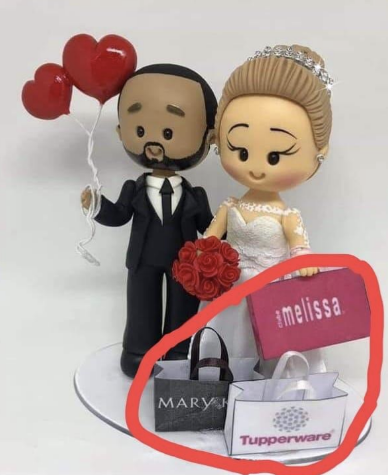 The cake topper has the bride and groom holding bags with brand names clearly advertised