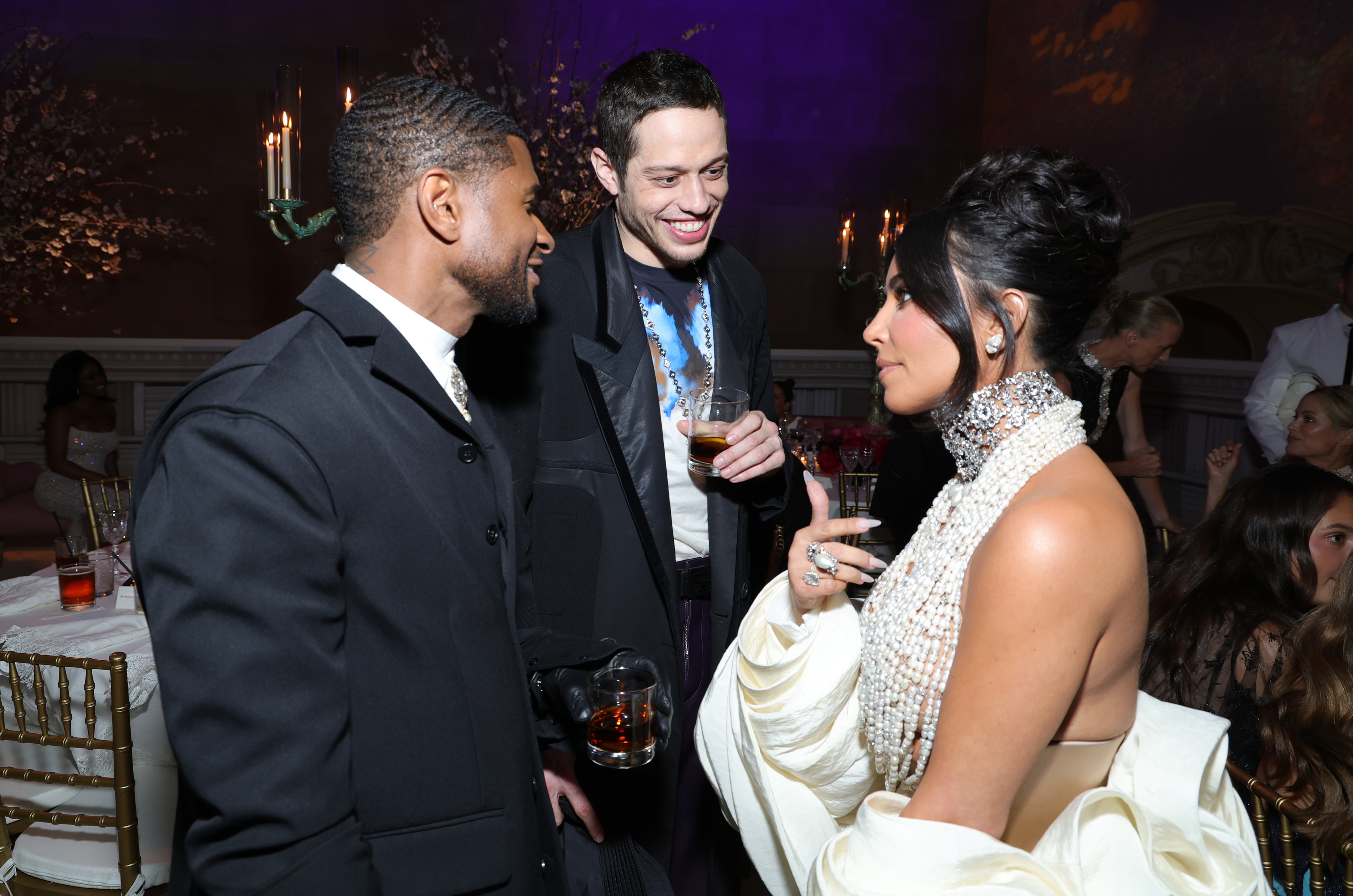 Kim talking to Usher and Pete Davidson at an event