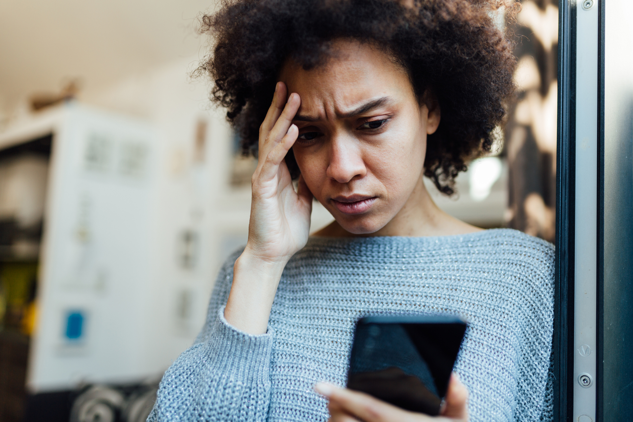 A woman looking stressed while looking at her phone