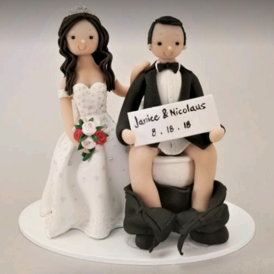 The topper shows a bride look normal, with her arm around the groom who is sitting on a toilet with his pants around his ankles and holding the date in front of his private parts