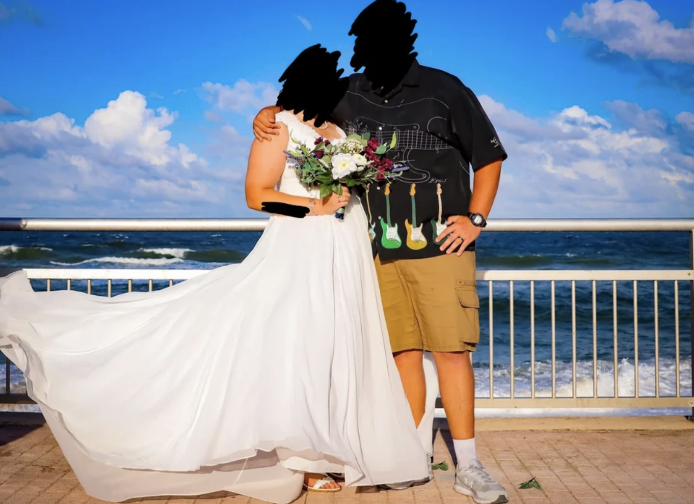 The bride is wearing a traditional wedding dress, while the groom is wearing cargo shorts, tennis shoes, and a graphic T-shirt covered in guitars