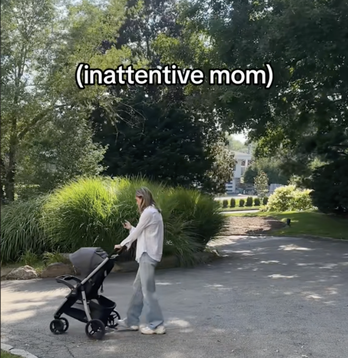 Mom on the phone pushing a baby carriage and checking her phone with &quot;inattentive mom&quot; caption