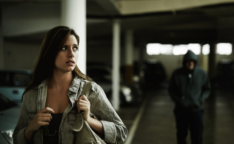 man following a woman in a parking garage