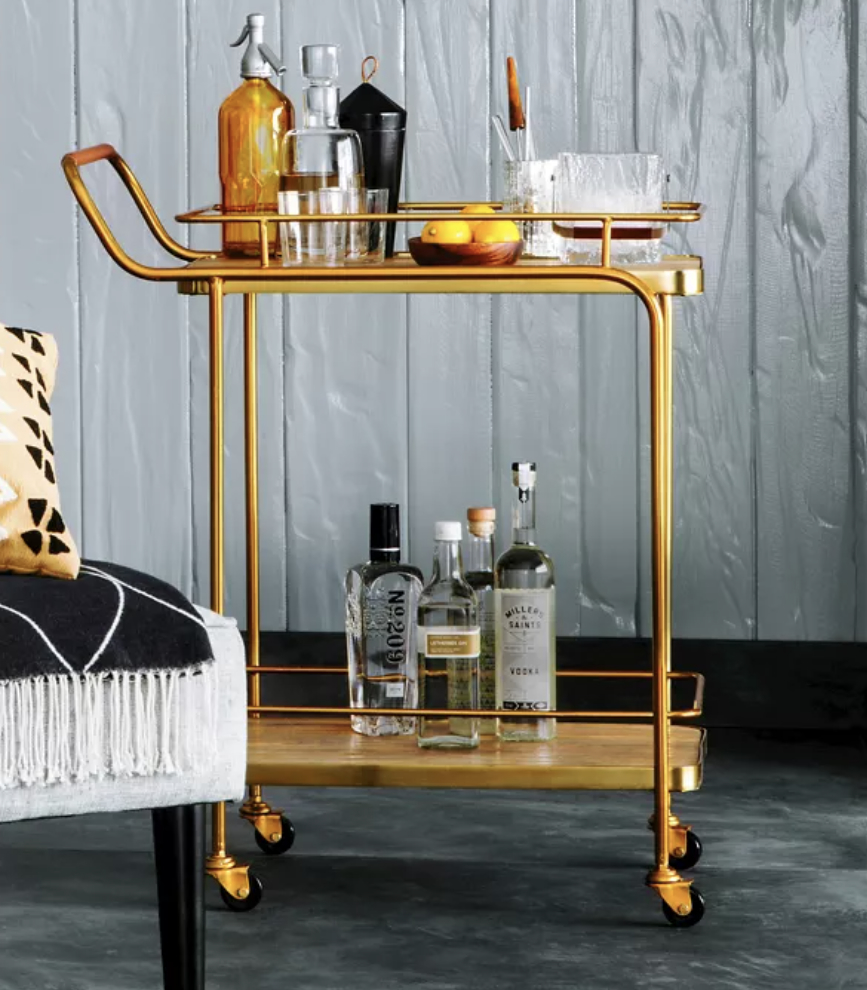 the gold bar cart with alcohol on it