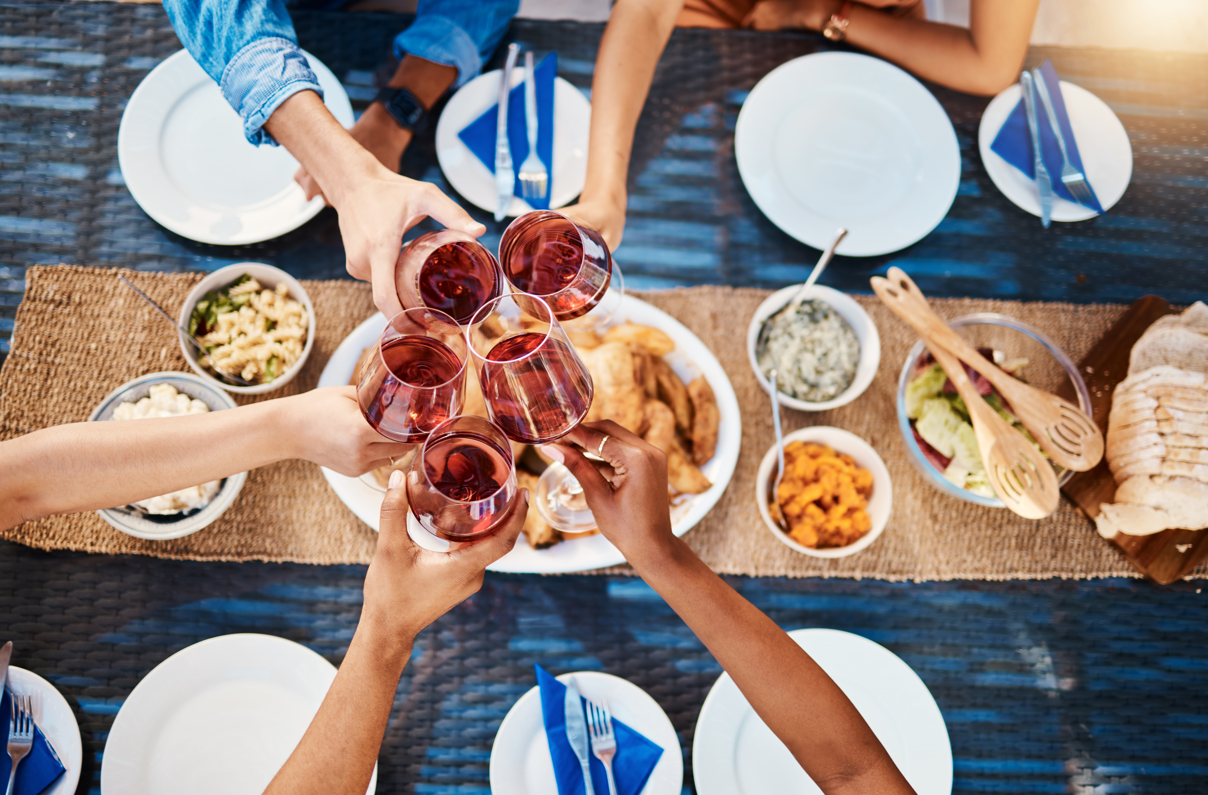 a group of people cheersing their drinks as they gather for a meal