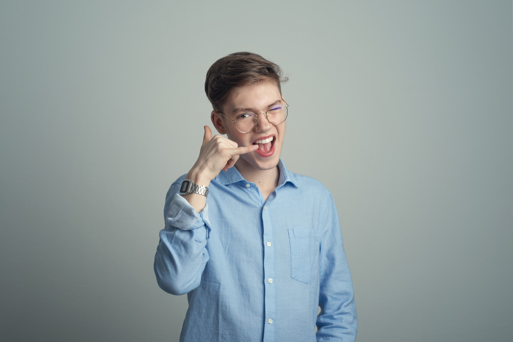 A kid making a phone gesture with their hand