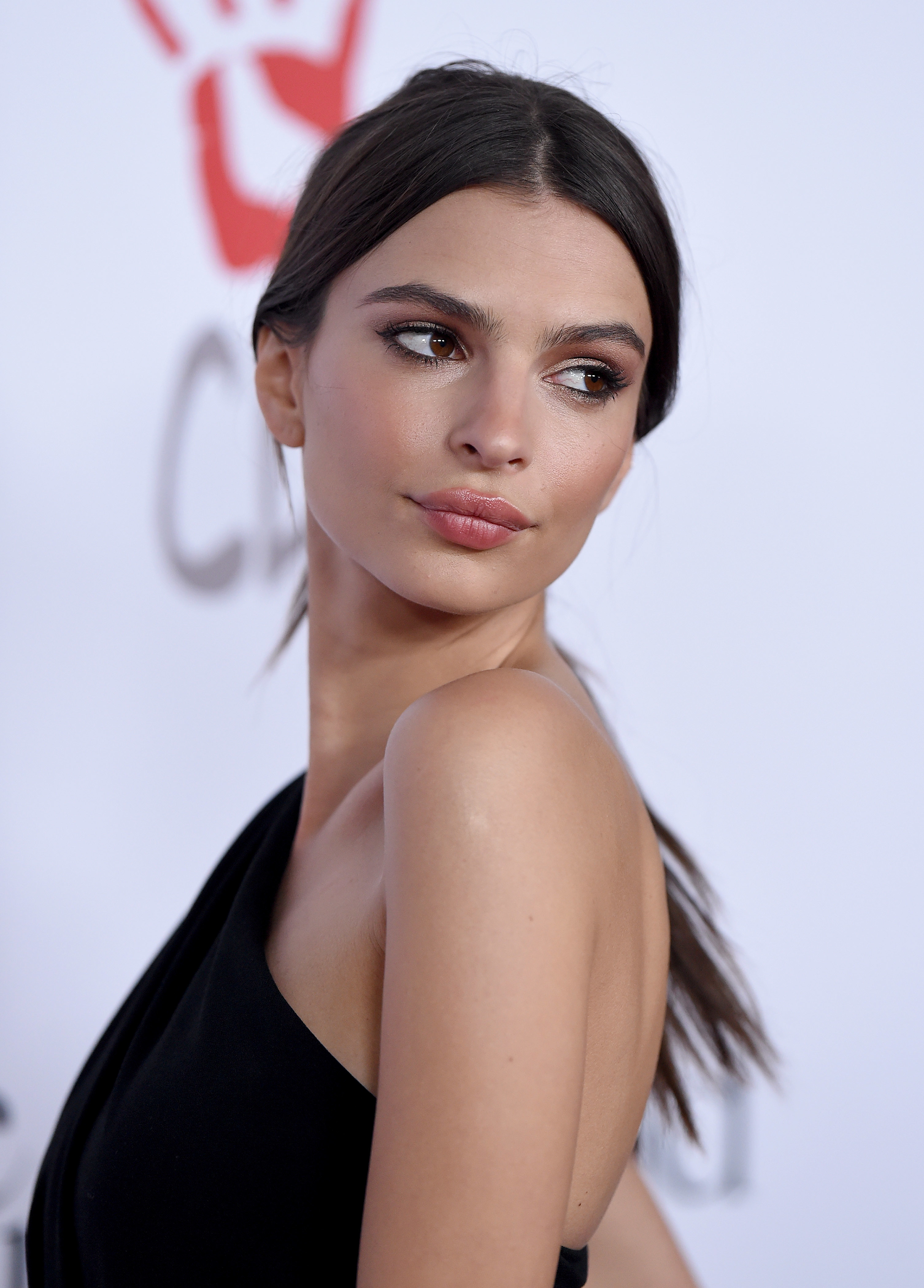 Close-up of Emily at a media event in a one-shoulder outfit