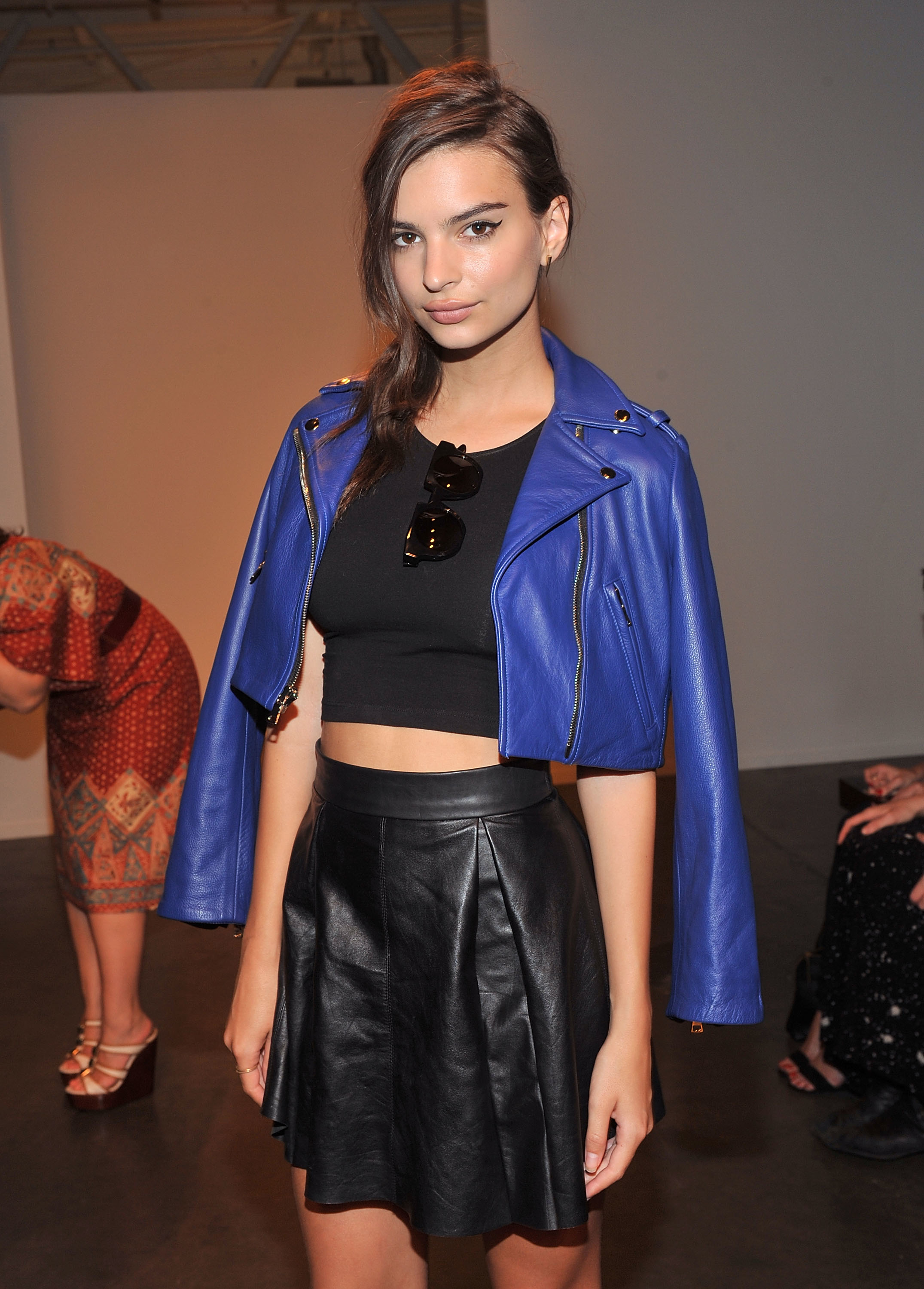 Close-up of Emily at a media event in a cropped jacket and top and miniskirt