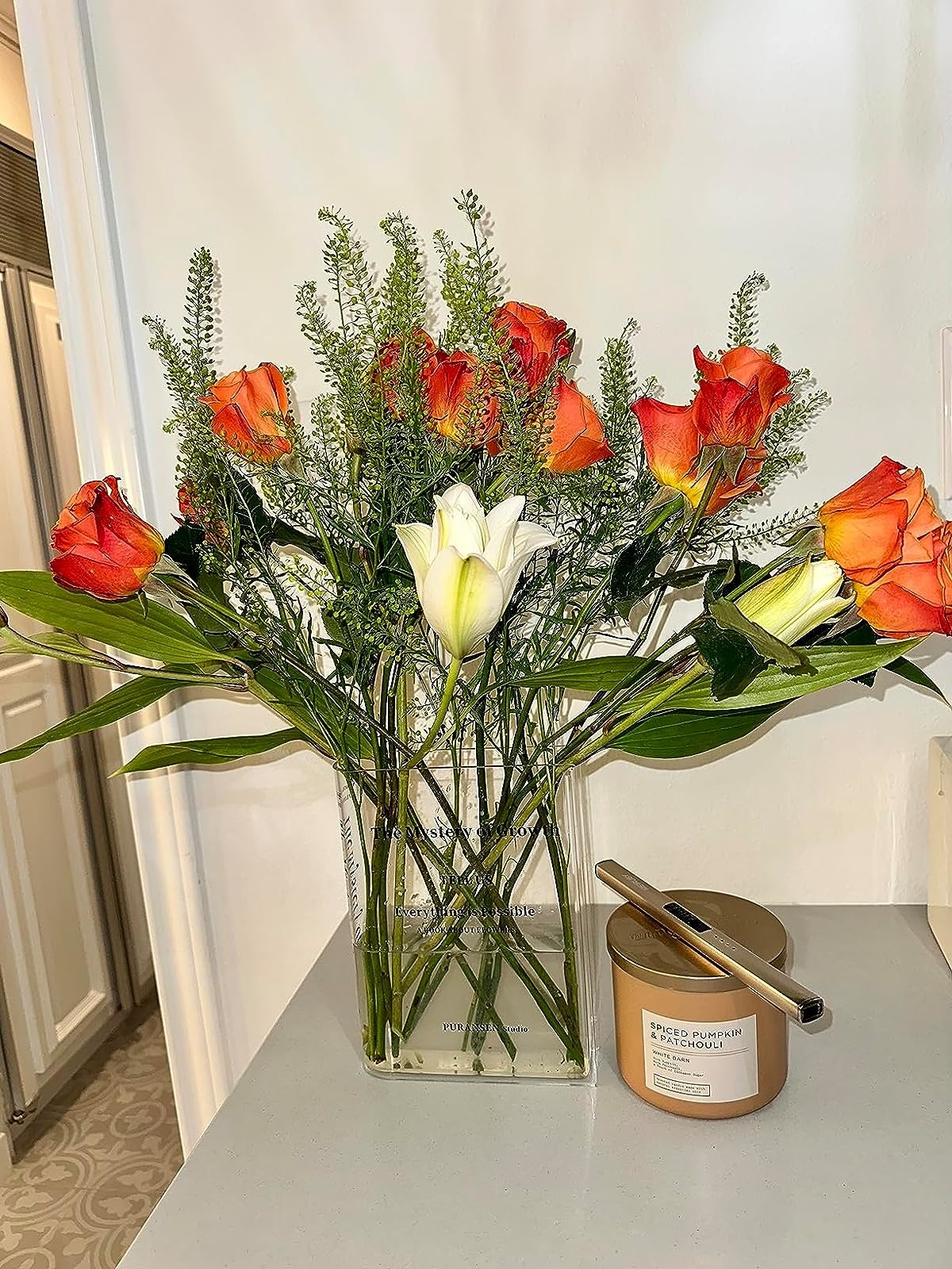 Reviewer&#x27;s photo of the vase in the color Transparent with a bouquet of orange roses inside