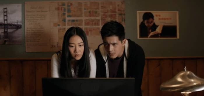 Two people looking intently at something on a computer