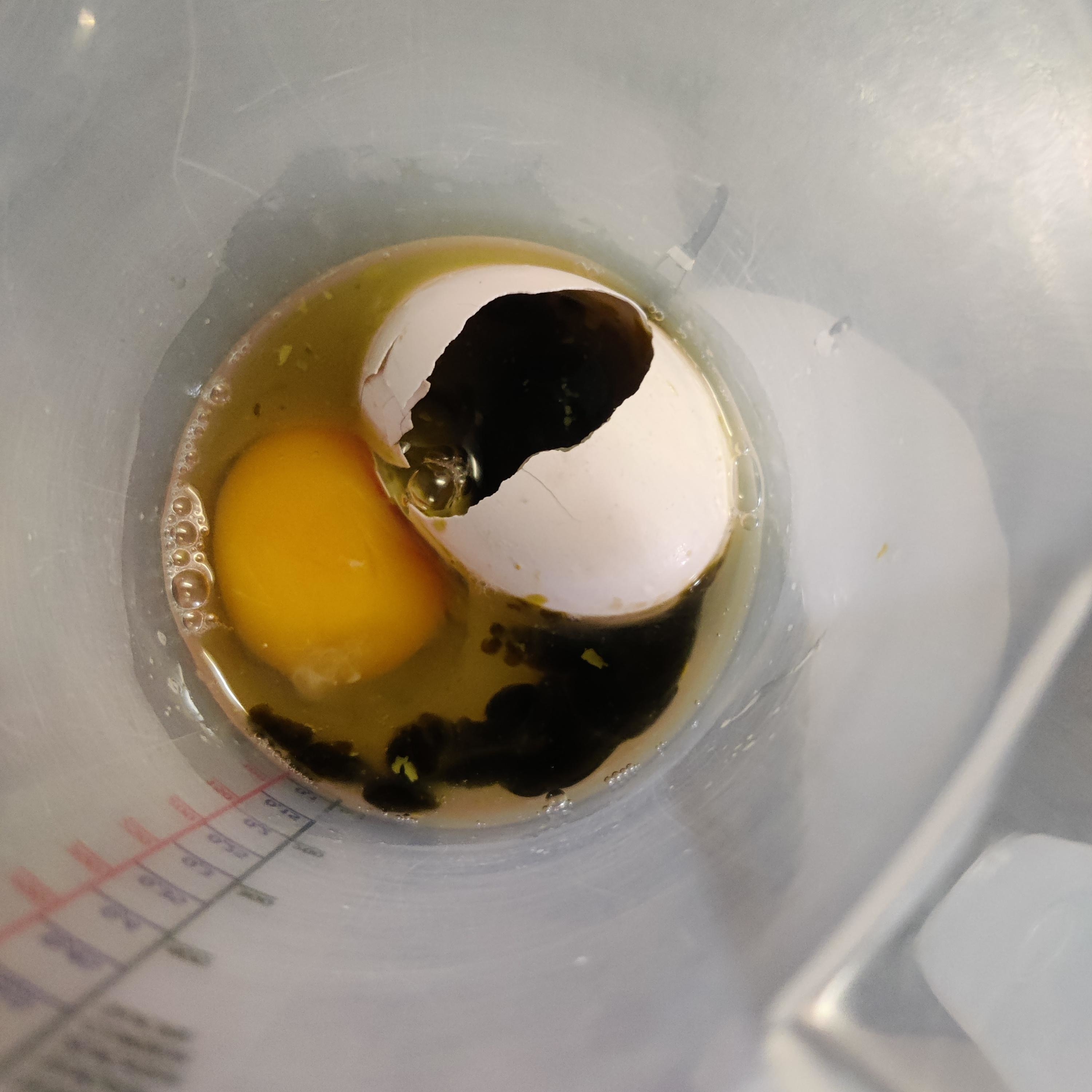 A cracked egg with lots of blood in the albumen