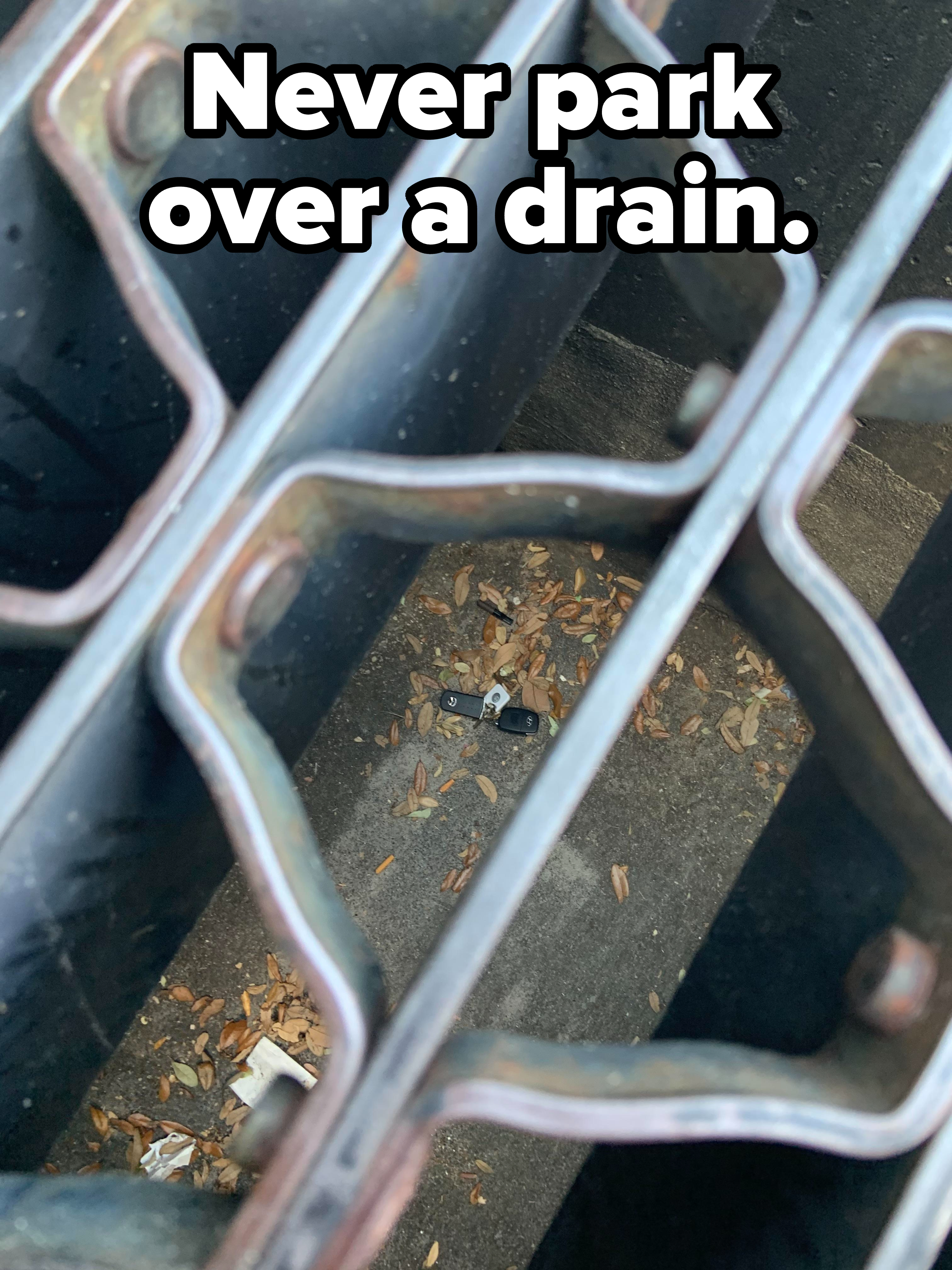 Car key fob at the bottom of a drain, as seen through a metal grate, with caption &quot;Never park over a drain&quot;