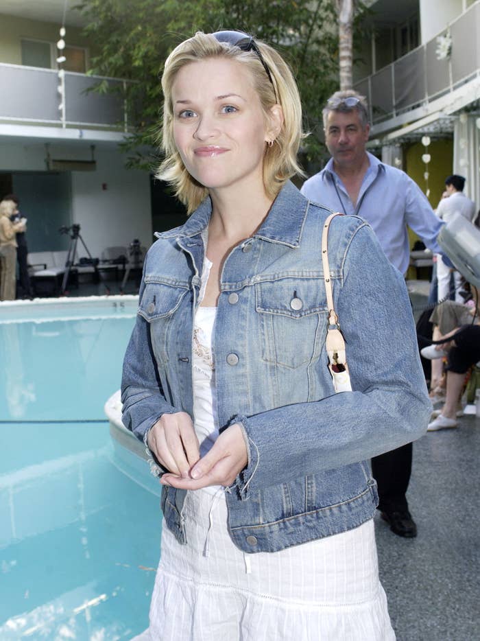 her hair is short and she's wearing a denim jacket over a dress