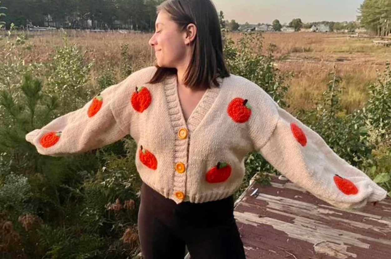 A person wearing the cardigan with their arms stretched out