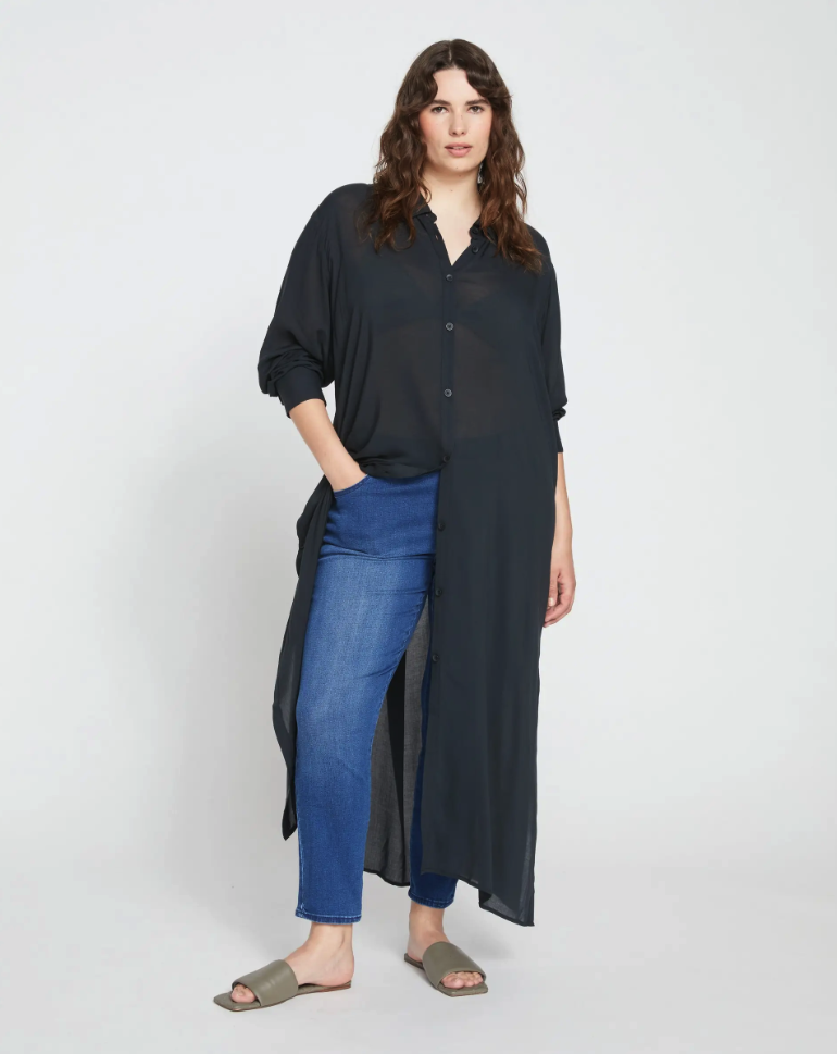 model wearing the black button tunic partially open with jeans and slides