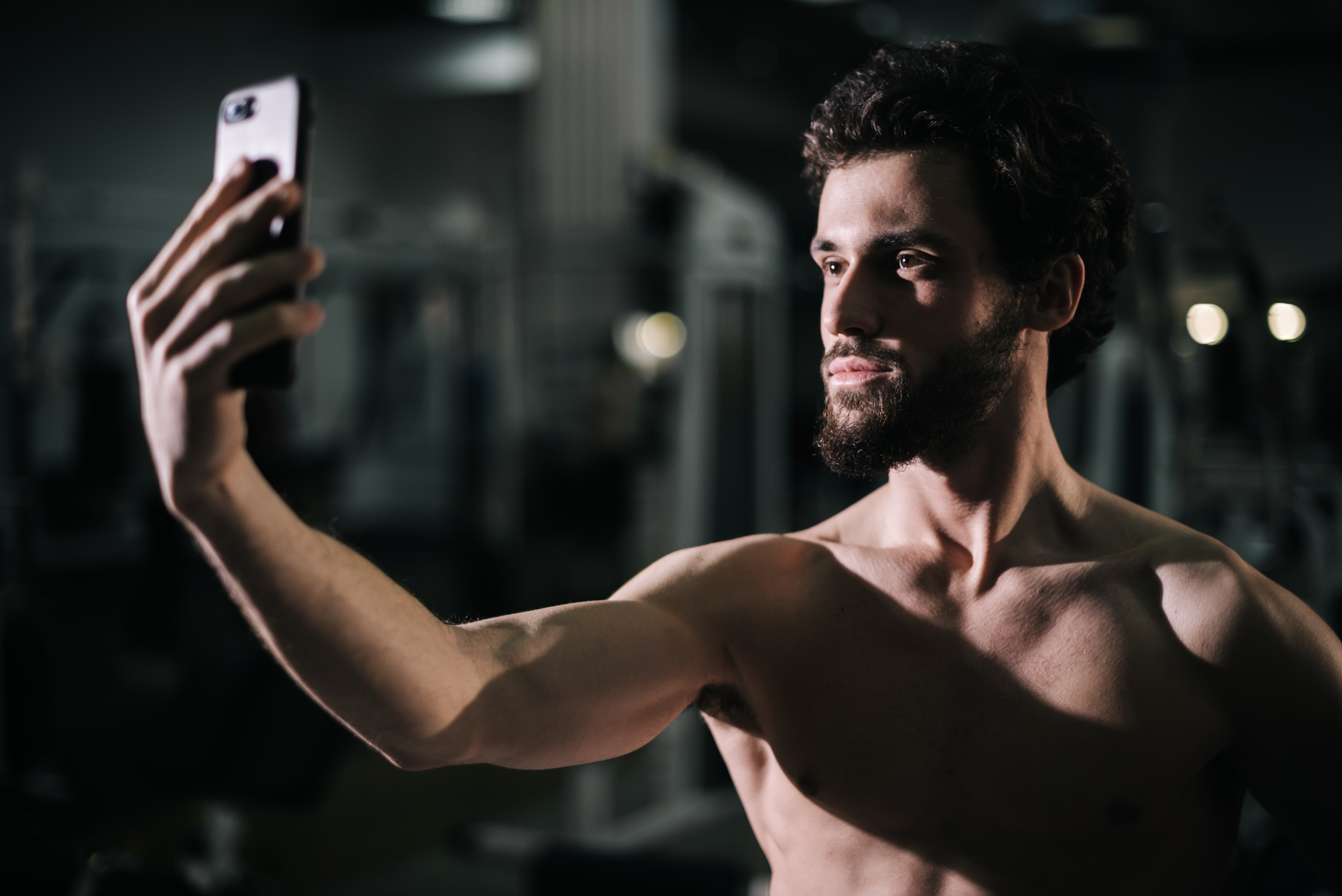 man taking a shirtless selfie at the gym
