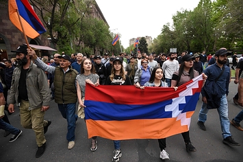 アルメニアの首都エレバンで行われた抗議デモで「アルツォフ共和国」の国旗を掲げるデモ隊（2022年5月撮影、AFP=時事）